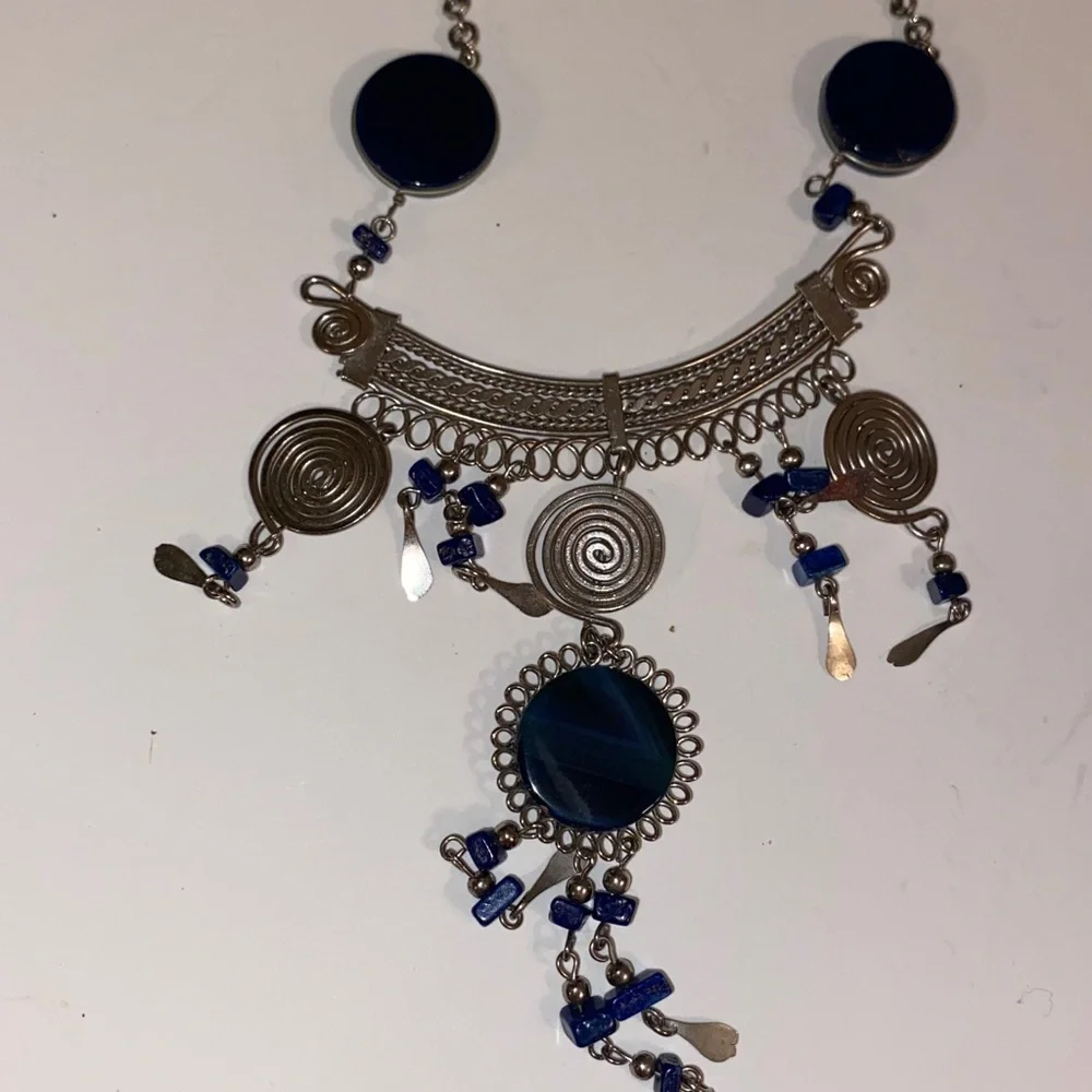 Ornate Silver-Toned Necklace with a Curved Center Adorned with Blue/Black Stones